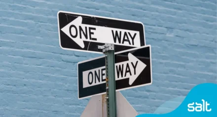 Close up of "One Way" roadway signs on a pole.