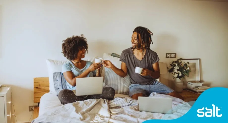 10 tips to transform your morning routine 1 Two people at home on their beds busy with a morning routine of coffee and starting work from home.