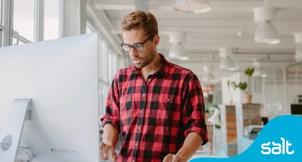 Man at a standing desk working on a computer.