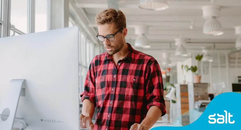 9 top tips to get your LinkedIn profile noticed 1 Man at a standing desk working on a computer.