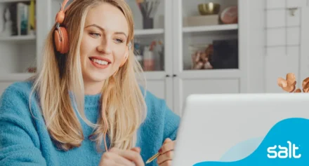 Woman with headphones in a virtual meeting working remotely.