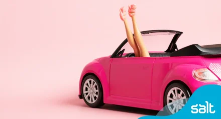 Barbie car with barbie in high heels in the car.