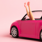 Barbie upside down in a pink car symbolising gender disparity and lack of female leaders