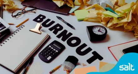 Close up of a messy desk with the word "burnout".