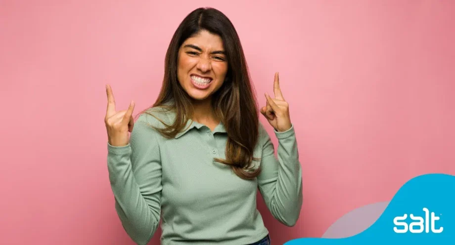 How to prepare for an interview to land your dream role 1 Woman standing with her fingers crossed for good luck looking excited.
