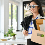 A woman leaving gracefully with sunglasses on and her box of things in her hands after submitting her resignation letter