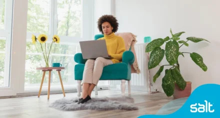 A woman sitting in a chair using a laptop.