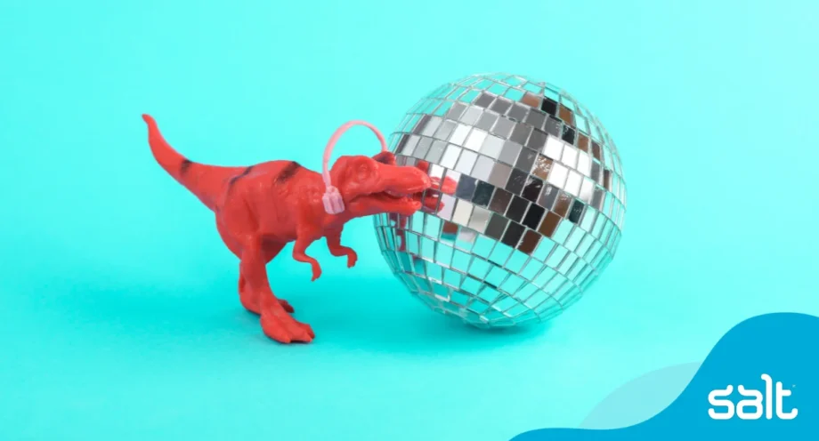 3 top tips to help attract and retain autistic talent 1 Playful red toy dinosaur with headphones and a disco ball, symbolising creativity, inclusion, and attracting autistic talent