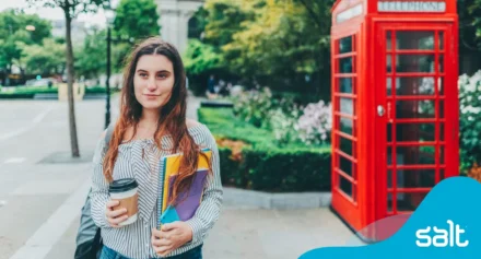 a woman holding books and a coffee cup