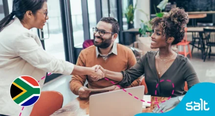 Diverse professionals in a modern office shaking hands, symbolising career opportunities and collaboration in South Africa