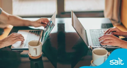 Two people working on a laptop side by side
