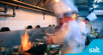 Chef in a kitchen with flames from the stove
