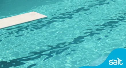 A diving board over a pool of clear blue water