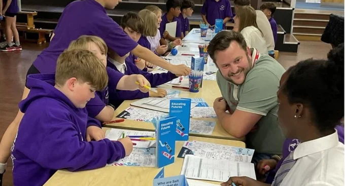 Students and a Salt colleague engaging in a career workshop activity at a school event