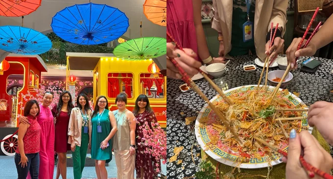 Colleagues celebrate Lunar New Year together, posing under colorful umbrellas and enjoying a traditional Yee Sang toss for prosperity and good fortune