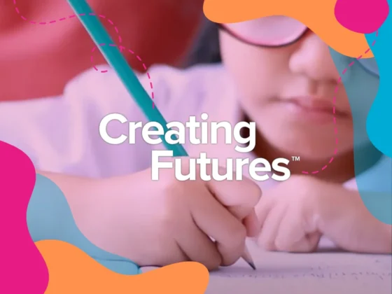 School girl writing in a book with the words "Creating Futures"