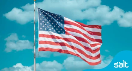 United States flag waving against a clear blue sky