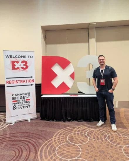 Man standing next to a D×3 sign at Canada's biggest retail marketing and technology event