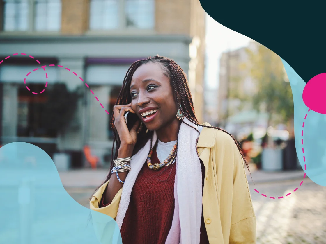 Smiling woman talking on the phone while walking in a city street