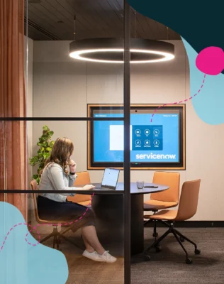 Woman working inside a ServiceNow boardroom