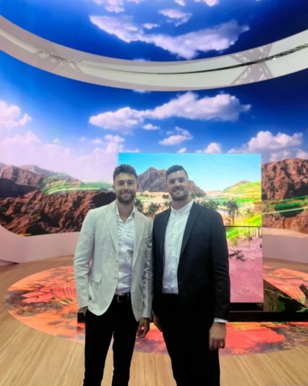 Two men in suits standing at the LEAP 2024 tech event in Saudi Arabia, with a large scenic digital display and sky-themed ceiling behind them.