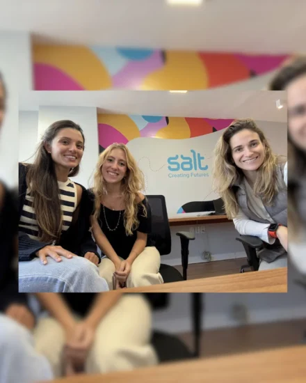 Three women smiling in an office with a colourful Salt “Creating Futures” wall in the background