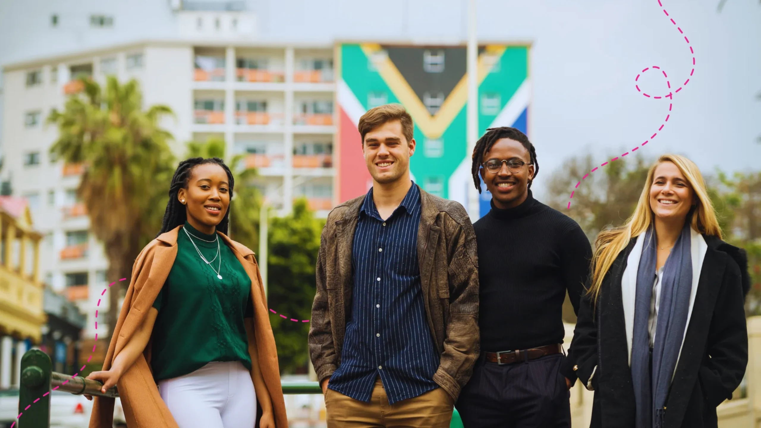 Four diverse colleagues standing in Cape Town city street with the South African flag in the background