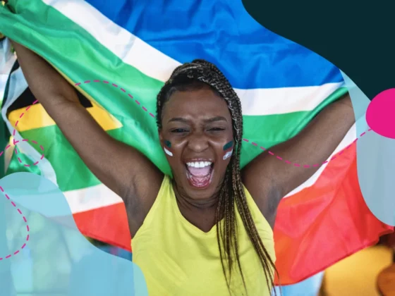 Woman in yellow shirt waving the South African flag behind her back