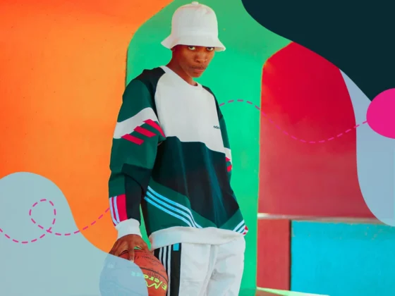 Man wearing Adidas clothes on standing in front of a colourful wall.