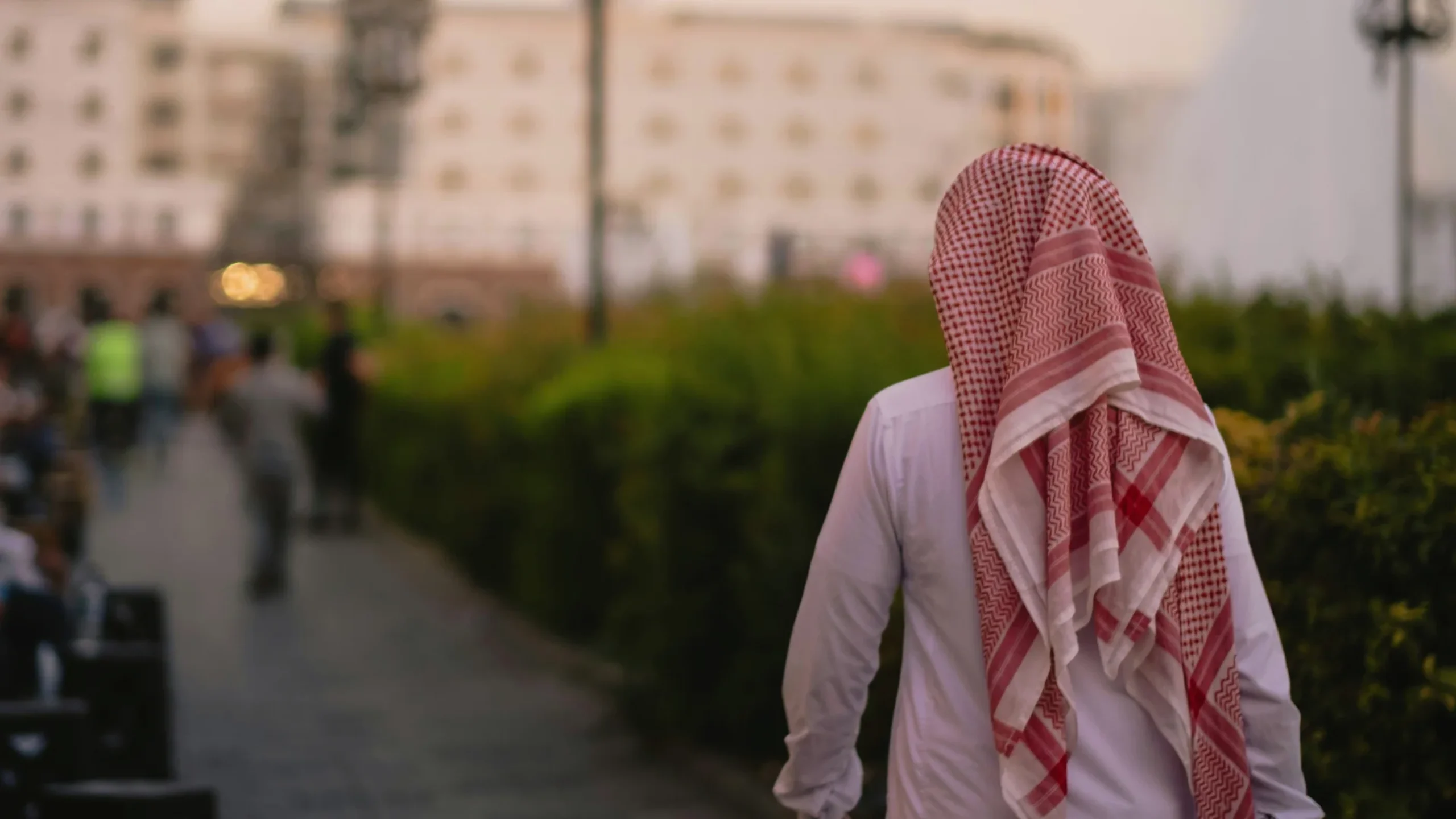 Emirati in traditional clothing walking on a sidewalk