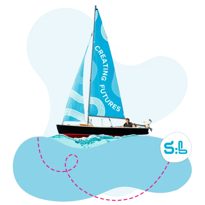 Man steering a sailboat with the the words "Creating Futures" on the sail