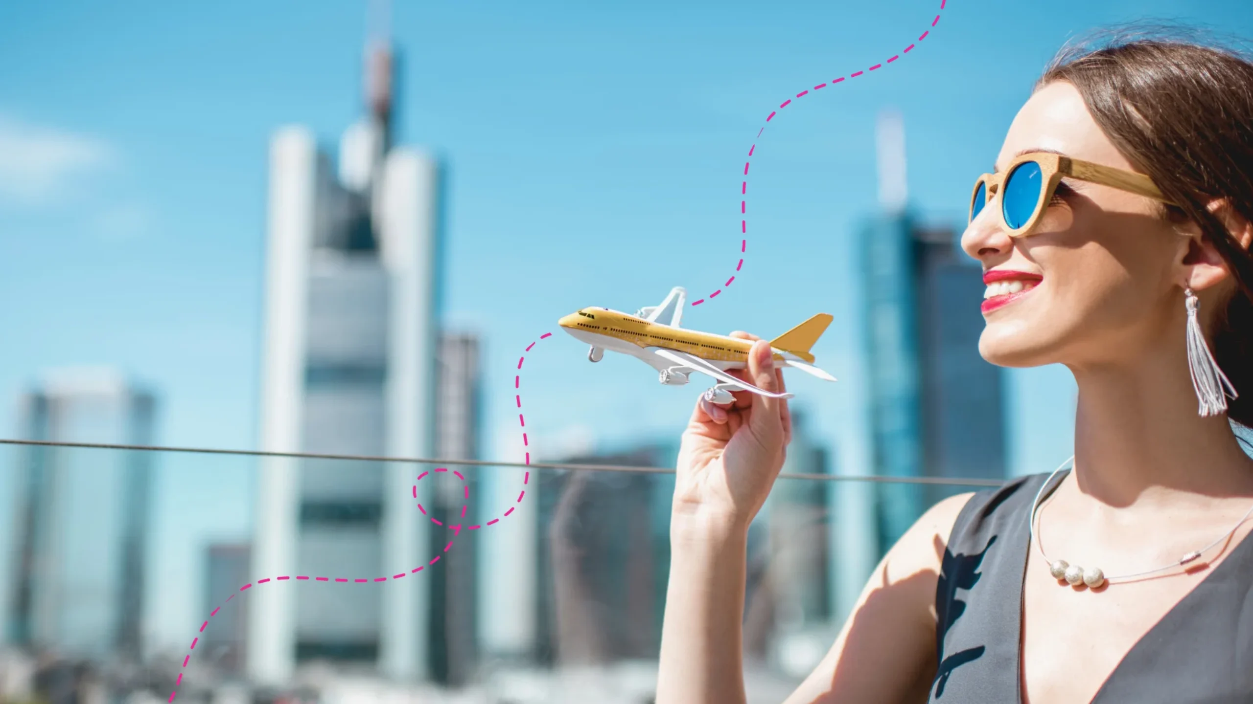 Woman with yellow toy aeroplane in her hand and Frankfurt city in the background.