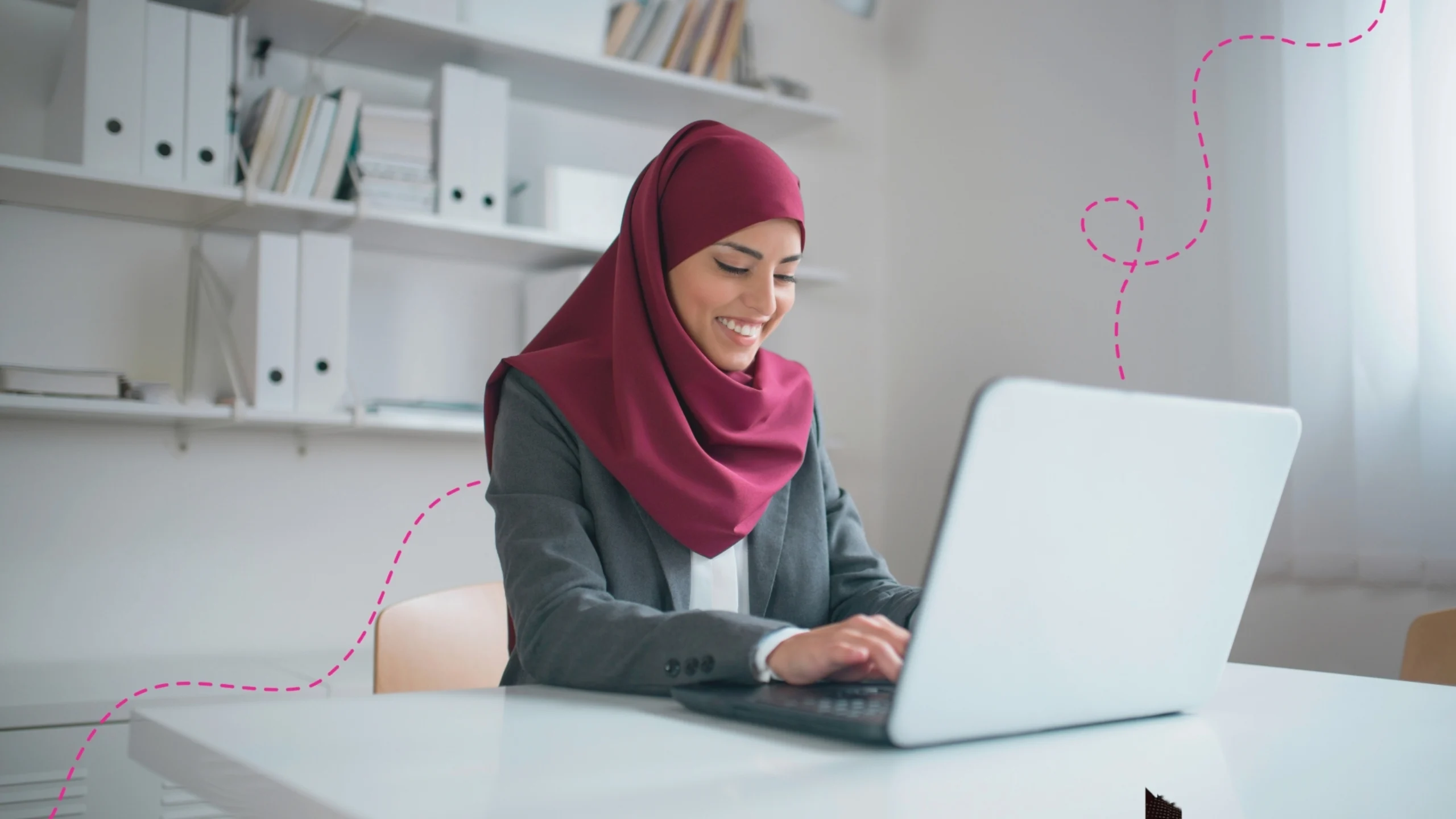 Emirate woman sitting at her desk working on her laptop