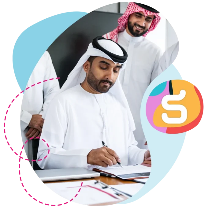 Saudi business men signing a contract at an office desk.