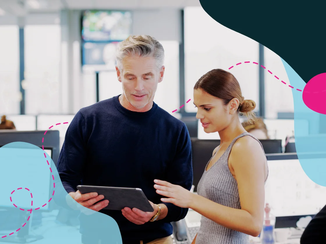 Two people working together looking at a tablet in an office