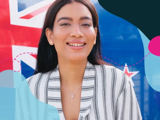 Woman in striped outfit with New Zealand flag in the background.