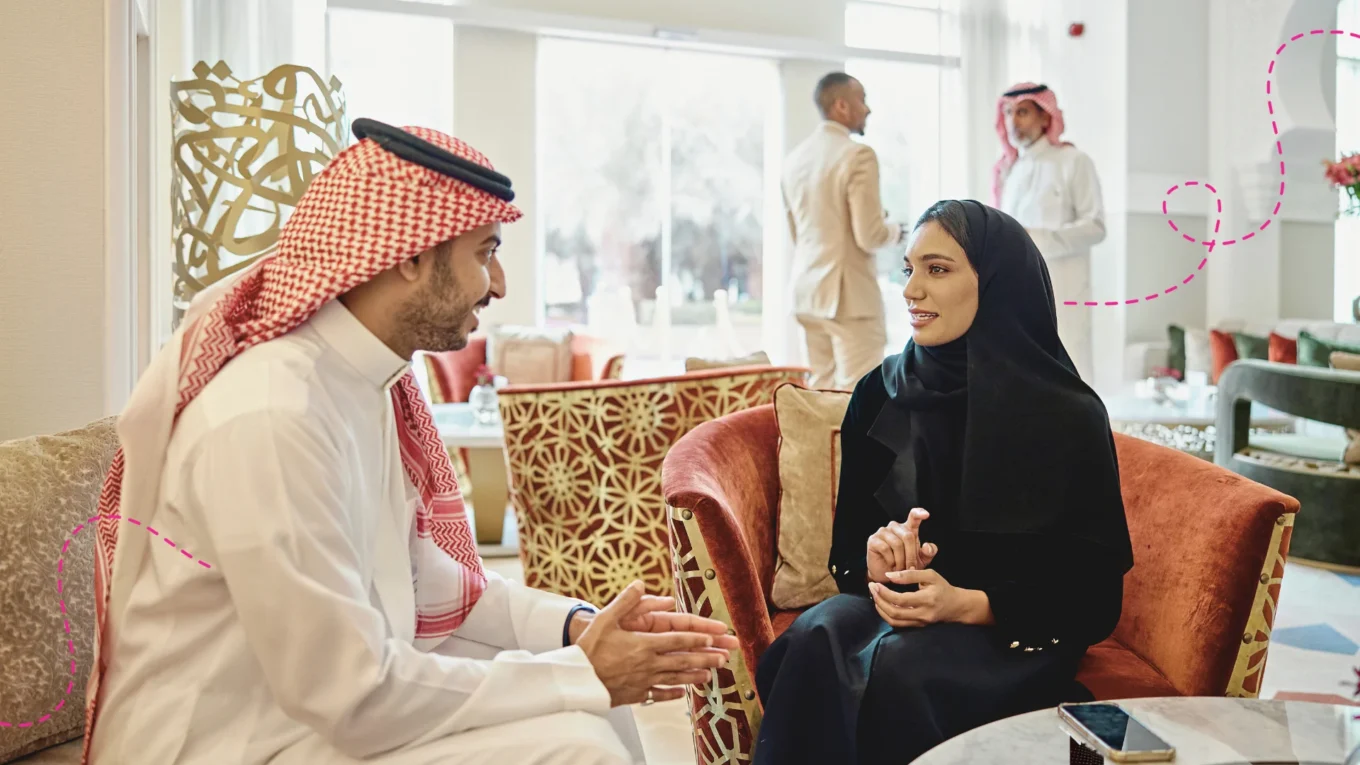 Two Saudi nationals in conversation in a office.