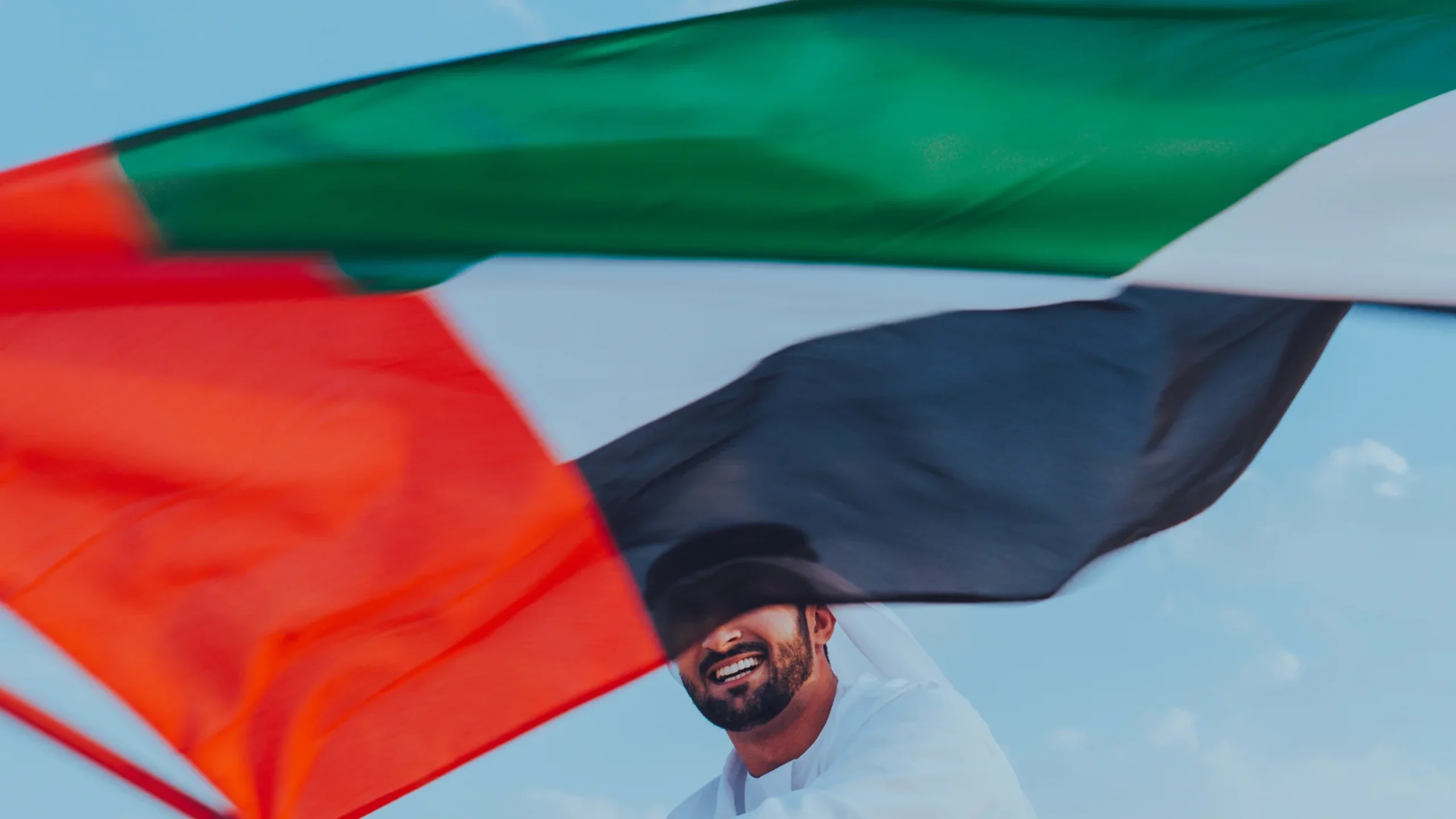 Emirati man waving the UAE flag.