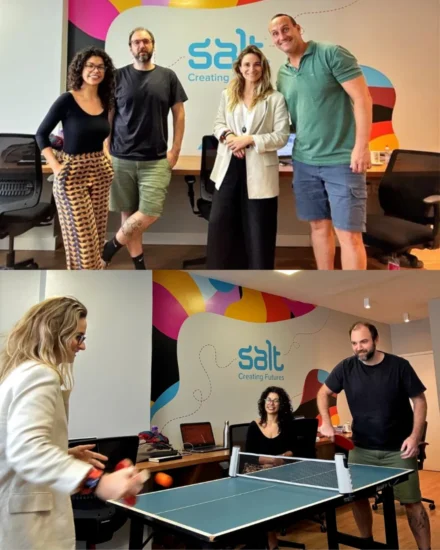 People in a colourful Salt office, posing for a group photo and playing a casual game of table tennis.