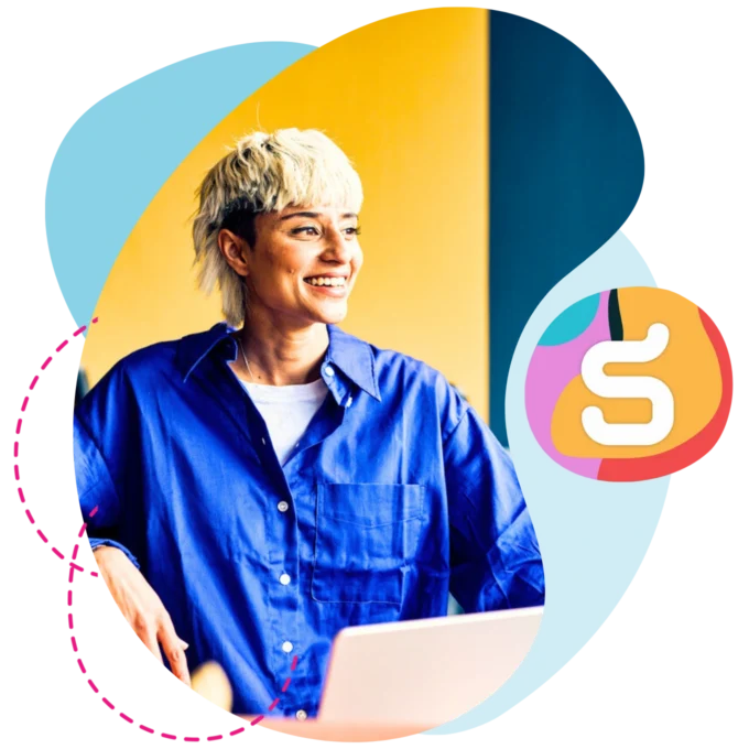 Person at work smiling with laptop.