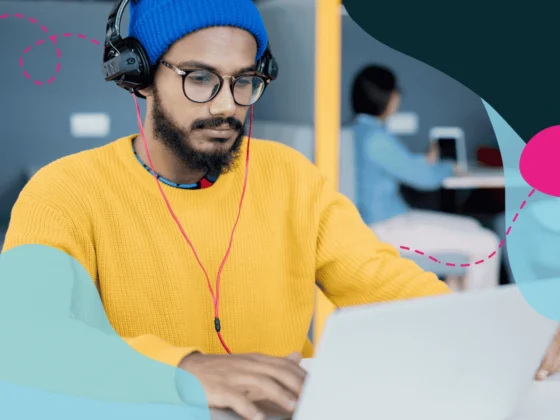 Tech worker in an open plan office on laptop