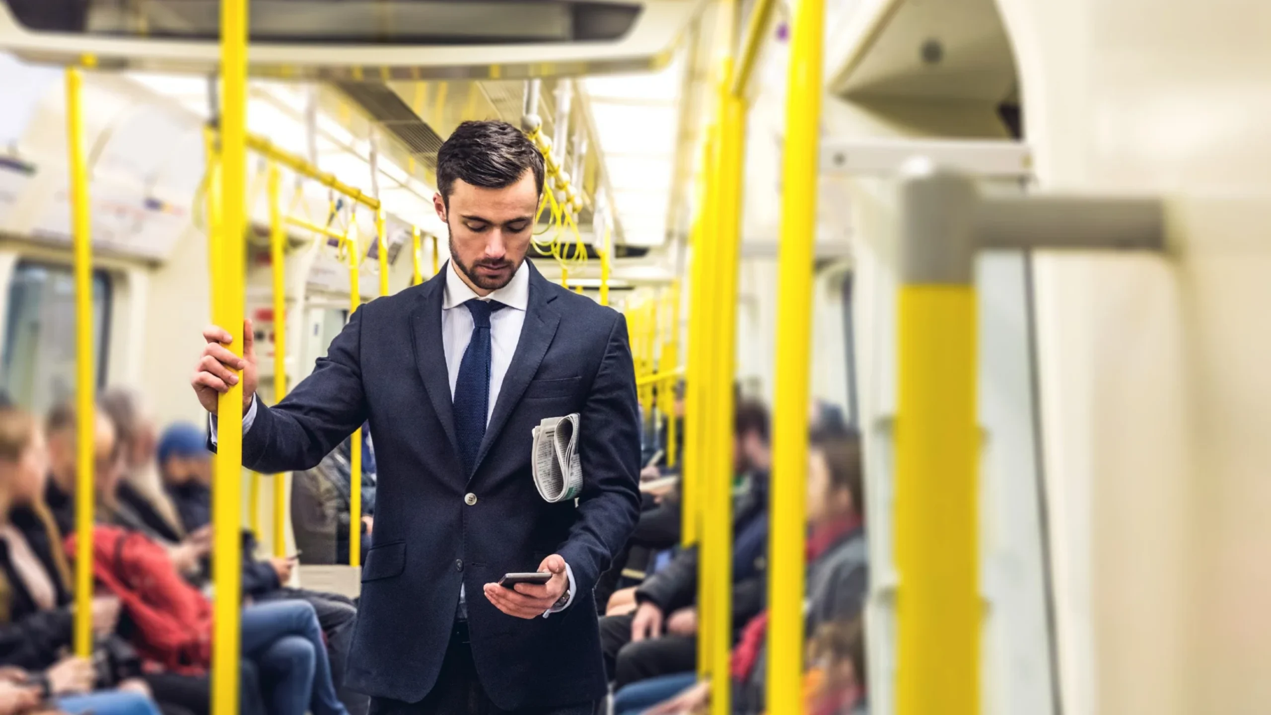 Business man looking at his phone on a British train