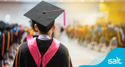 A graduate in cap and gown looking forward